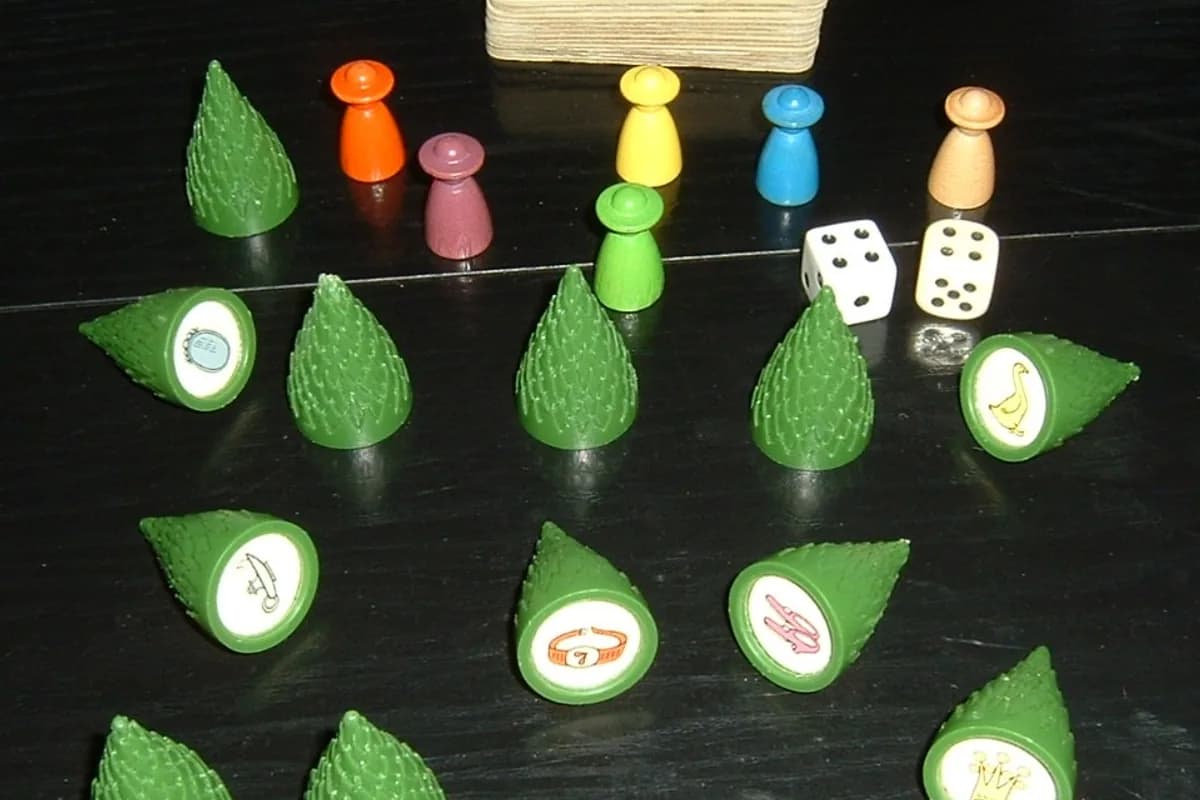 Pions de bois colorés, sapins verts, dés et paquet de cartes du jeu Sagaland, lauréat historique du Spiel des Jahres en 1982